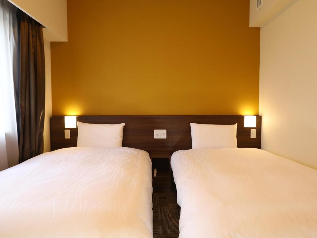 Postel nebo postele na pokoji v ubytování Dormy Inn Ikebukuro