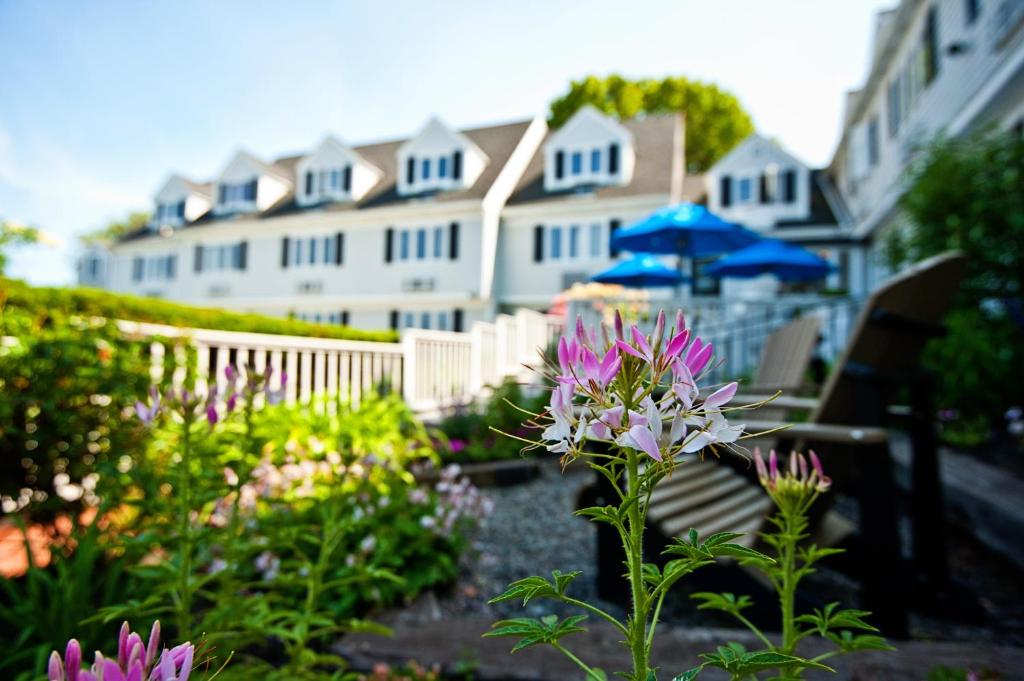 a garden with flowers and a house in the background at The Inn at Scituate Harbor in Scituate