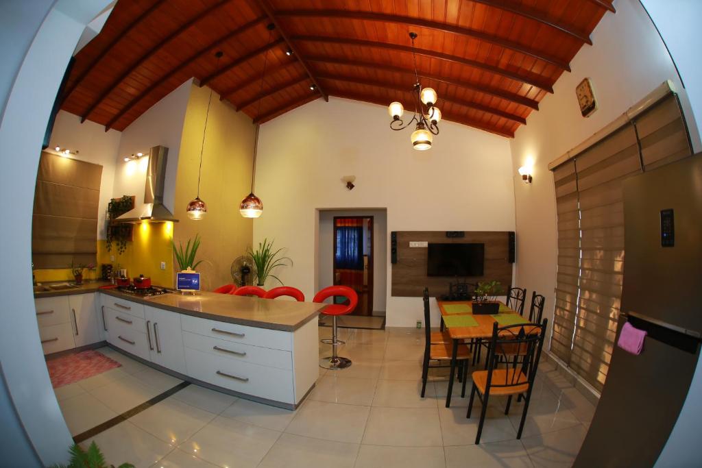 una cucina e una sala da pranzo con tavolo e sedie di Colombo Orchid Villa a Colombo