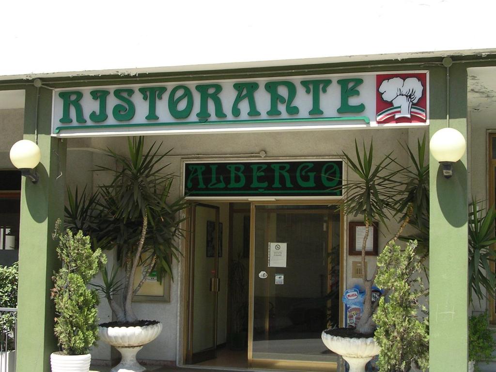 een toegang tot een restaurant met planten ervoor bij Albergo Tenda Verde in Falconara Marittima