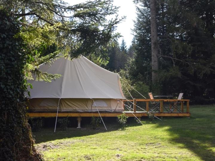 a large tent in a field next to a table at Glamping at Camping La Source in Saint-Pierre-dʼArgençon