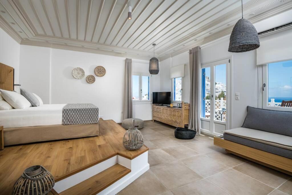 1 dormitorio con 1 cama y 1 sofá en Luxury Apartment in the Heart of Astypalaia, en Astipalea