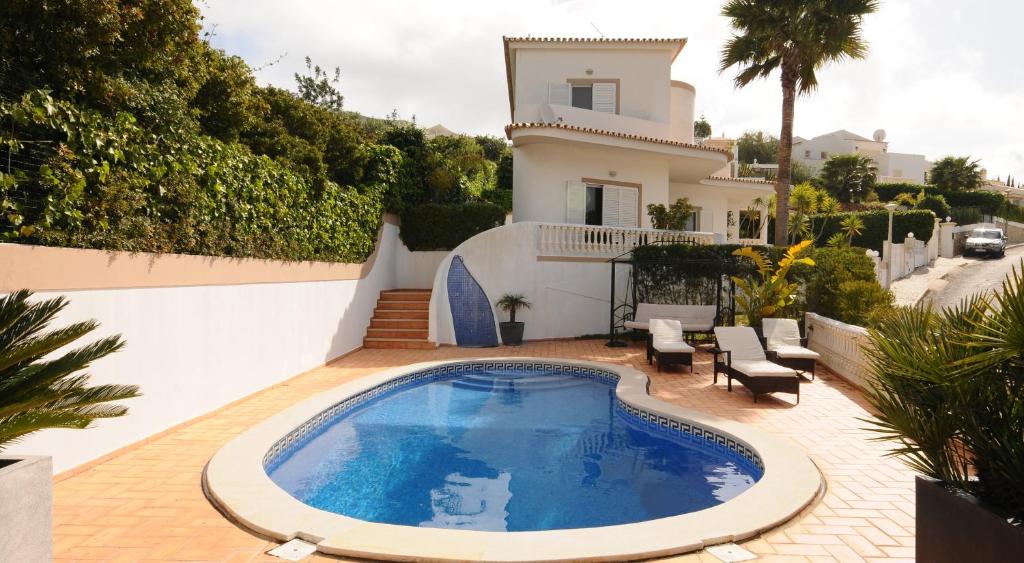 Villa con piscina frente a una casa en Albufeira Villa Okapi, en Albufeira