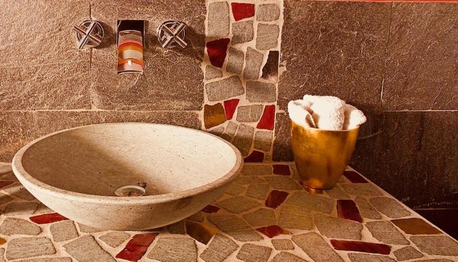 a bathroom with a toilet and a trash can at Cascina Canée in Angera