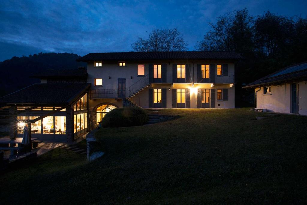 a large house at night with its lights on at Cascina Canée in Angera