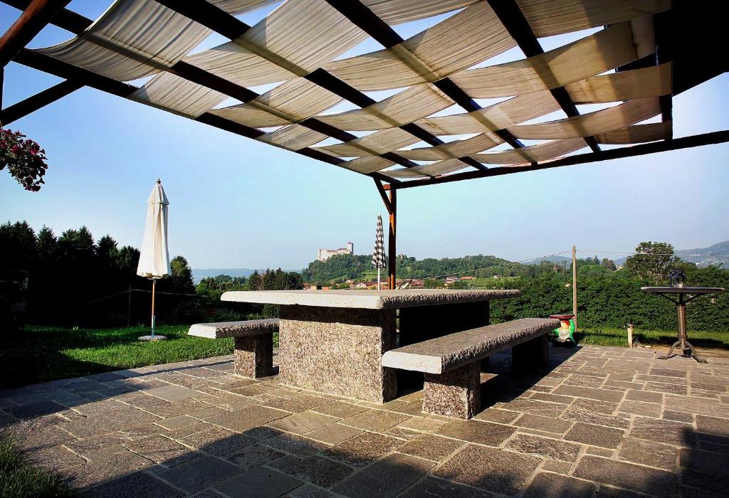 a picnic table and an umbrella on a patio at Cascina Canée in Angera