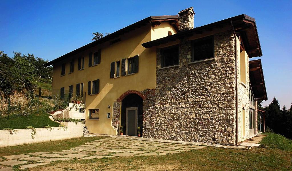 a brick building with a door and a stone driveway at Cascina Canée in Angera