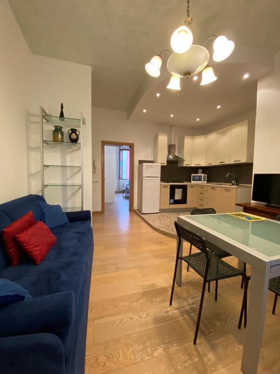 Ca' Santa Marta Apartment في البندقية: غرفة معيشة مع أريكة زرقاء وطاولة
