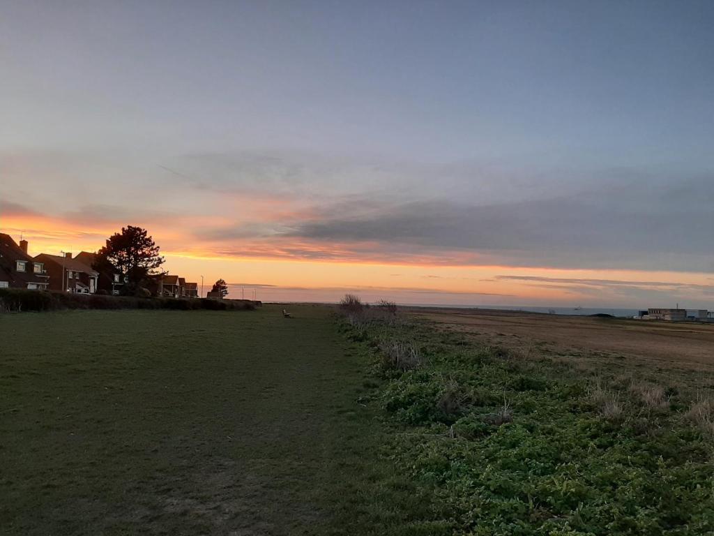 a field of grass with a sunset in the background at Home from Home Stay Margate in Margate