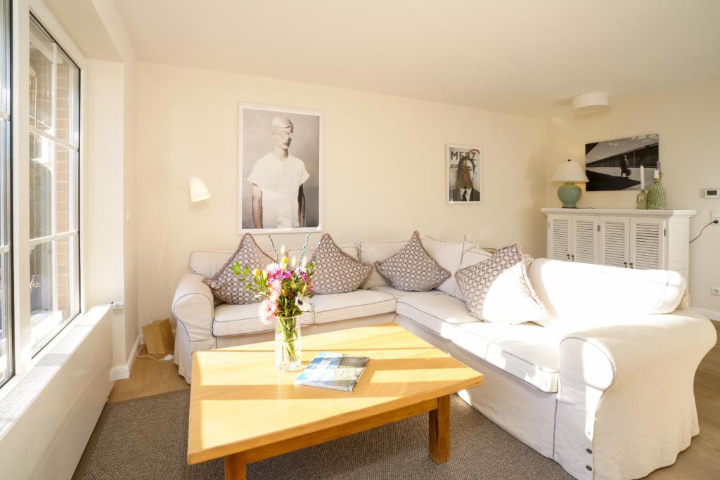 a living room with a white couch and a coffee table at Ferienhaus Frieda Sylt in Tinnum