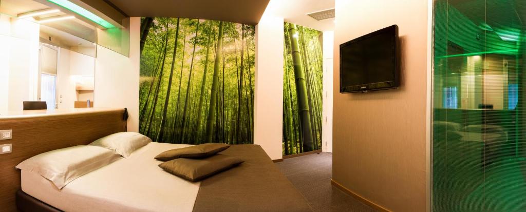 sypialnia z łóżkiem, telewizorem i oknem w obiekcie Pineta Hotel w mieście Monsano