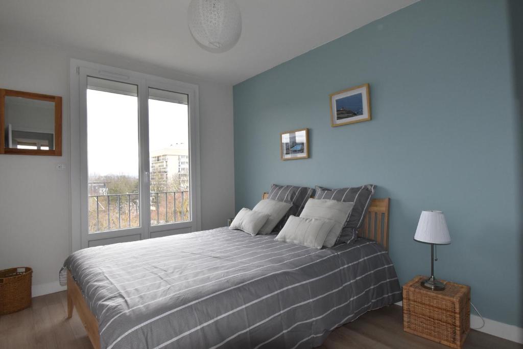 une chambre avec un lit et une grande fenêtre dans l'établissement La Belle Chanteraine, à Reims