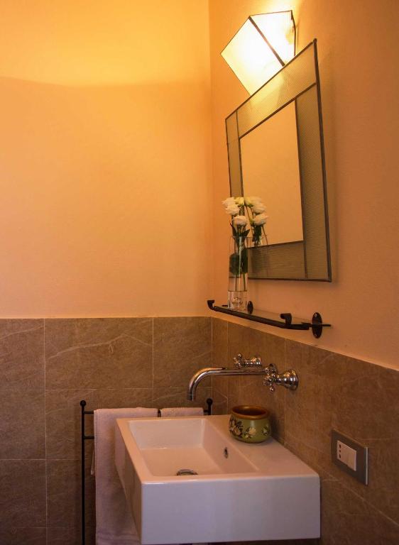 a bathroom with a white sink and a mirror at Cascina Canée in Angera