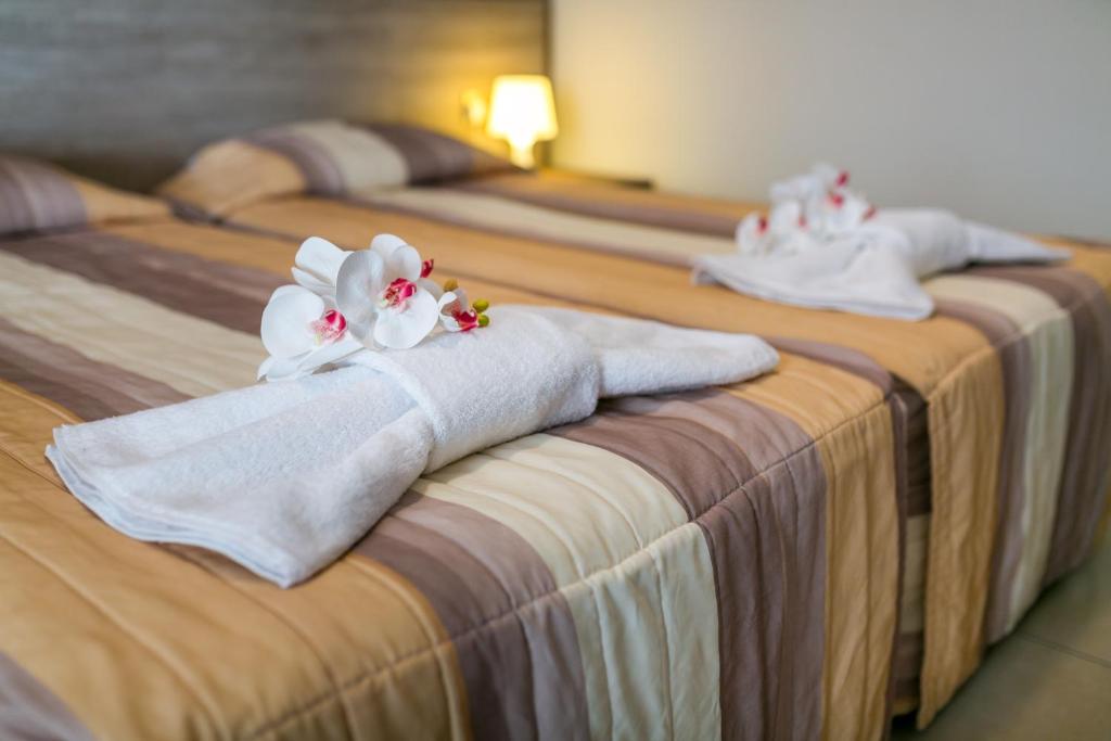 a group of three beds with towels on them at Crystallo Apartments in Paphos
