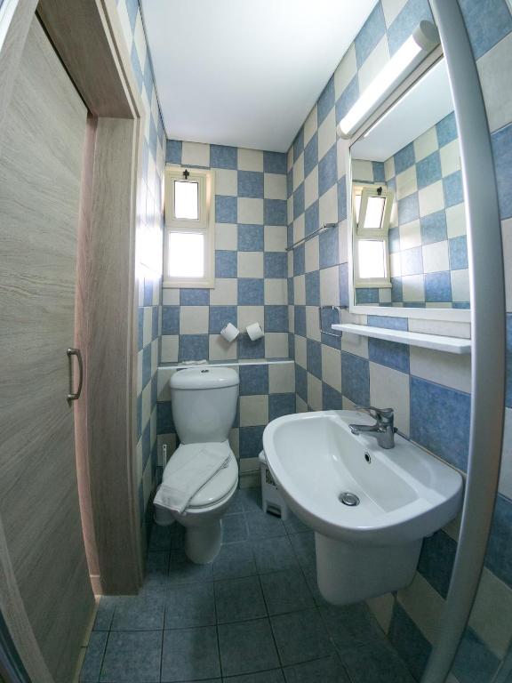 a bathroom with a toilet and a sink and a mirror at Crystallo Apartments in Paphos