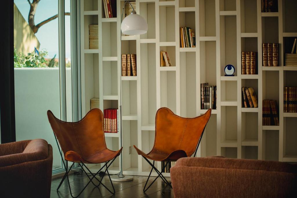 two chairs in a room with a book wall at A House in Estoril - Adults Only in Estoril