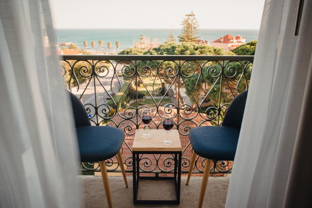 a balcony with two chairs and a table with a view of the ocean at A House in Estoril - Adults Only in Estoril