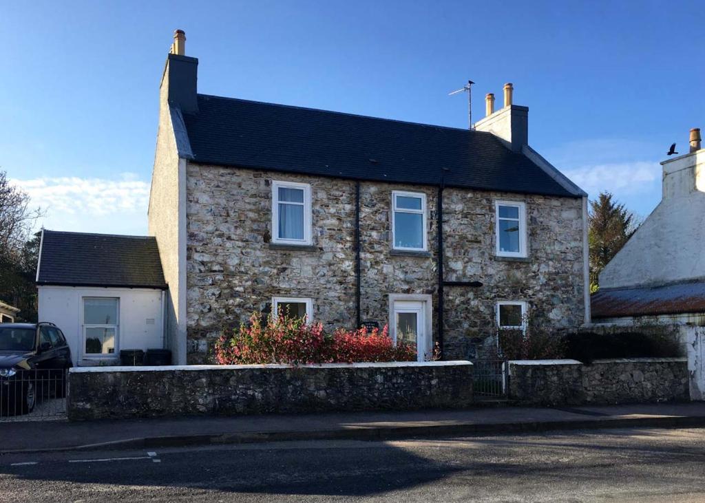 a stone house with a car parked in front of it at An Cuan Bed & Breakfast in Bowmore