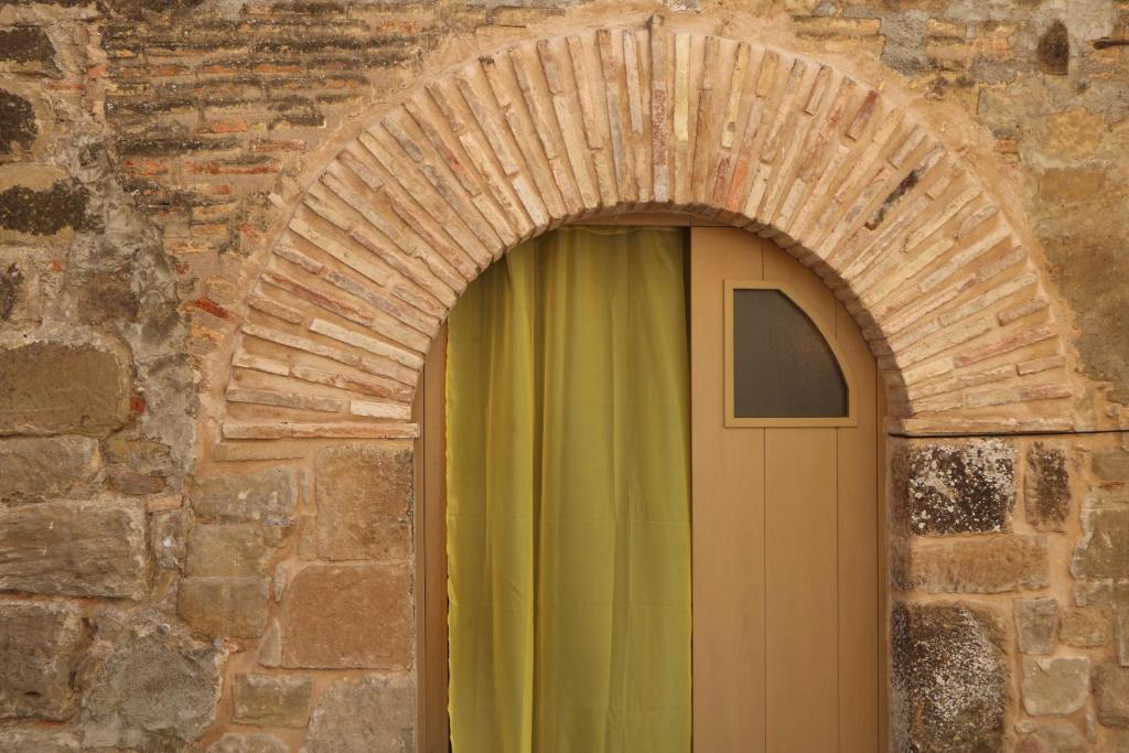 un arco con una puerta en una pared de ladrillo en Apartamento Casa Mía, en Adahuesca