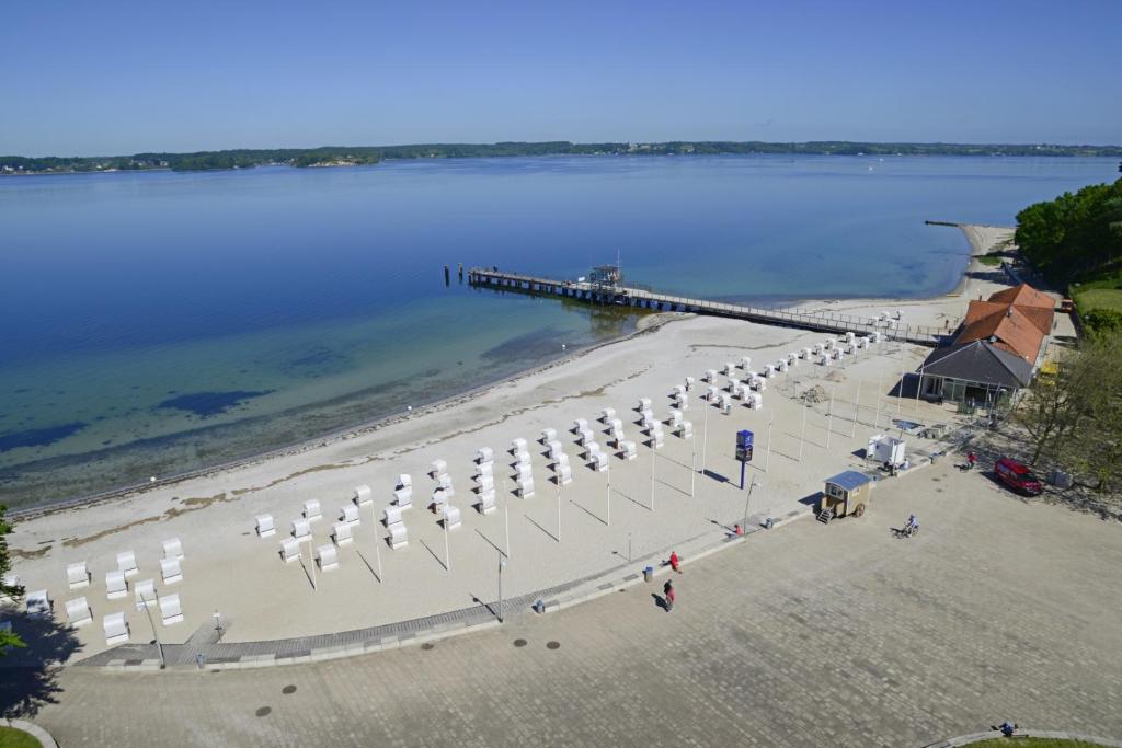 an aerial view of a beach with umbrellas and a pier at fewo1846 Intermar - Rooftop - Luxuriöses Studioapartment mit Balkon und Meerblick im 7 OG in Glücksburg