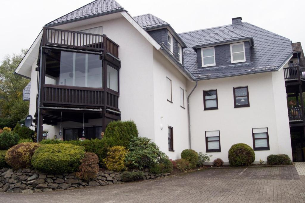 a white house with a black roof at Winterberg Appartement 21103 in Winterberg
