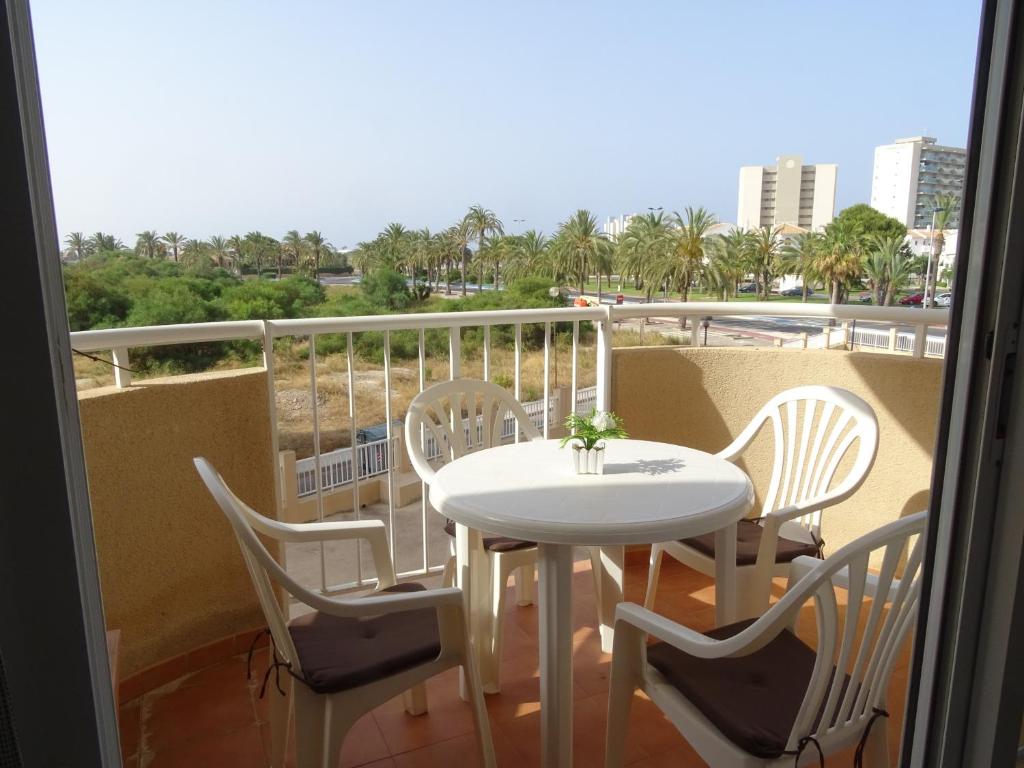 d'une table et de chaises blanches sur un balcon avec vue. dans l'établissement Canales de Veneciola, à La Manga del Mar Meno