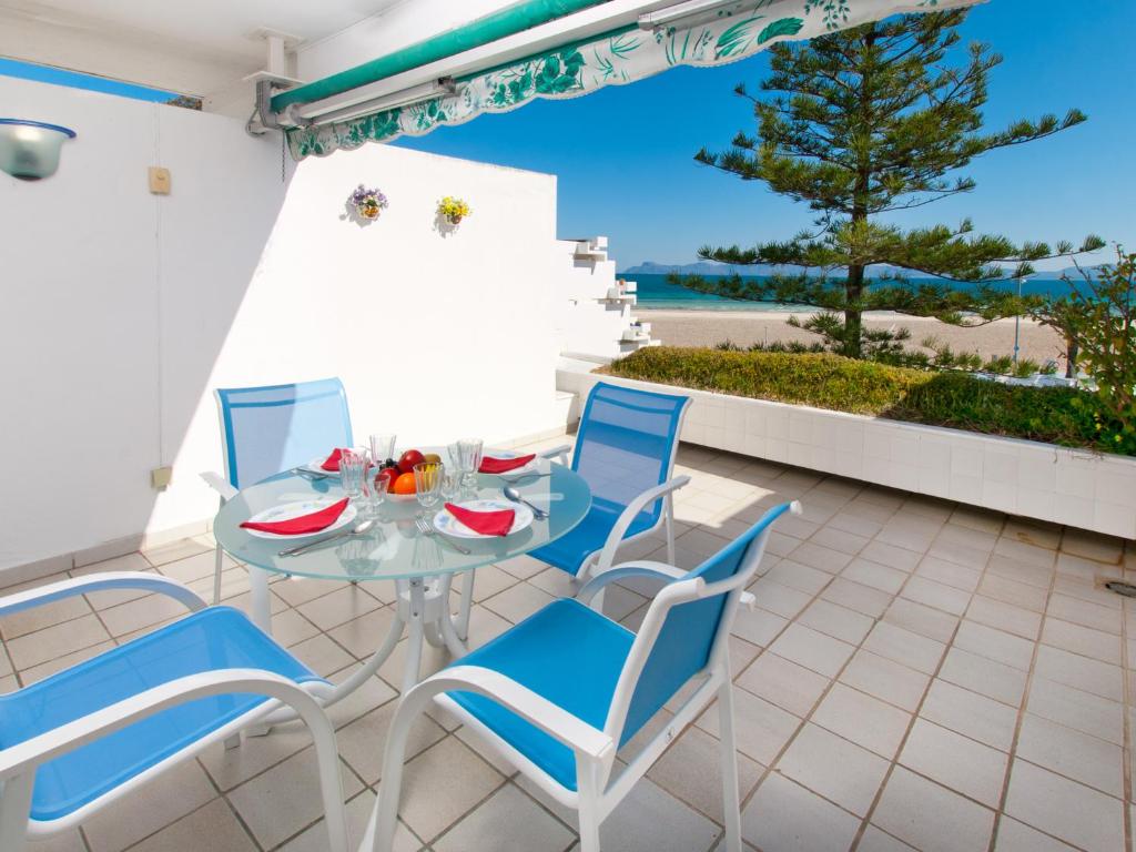 un patio con tavolo, sedie e vista sull'oceano di Apartment Oiza Canopus Sea Views at the beach a Alcudia