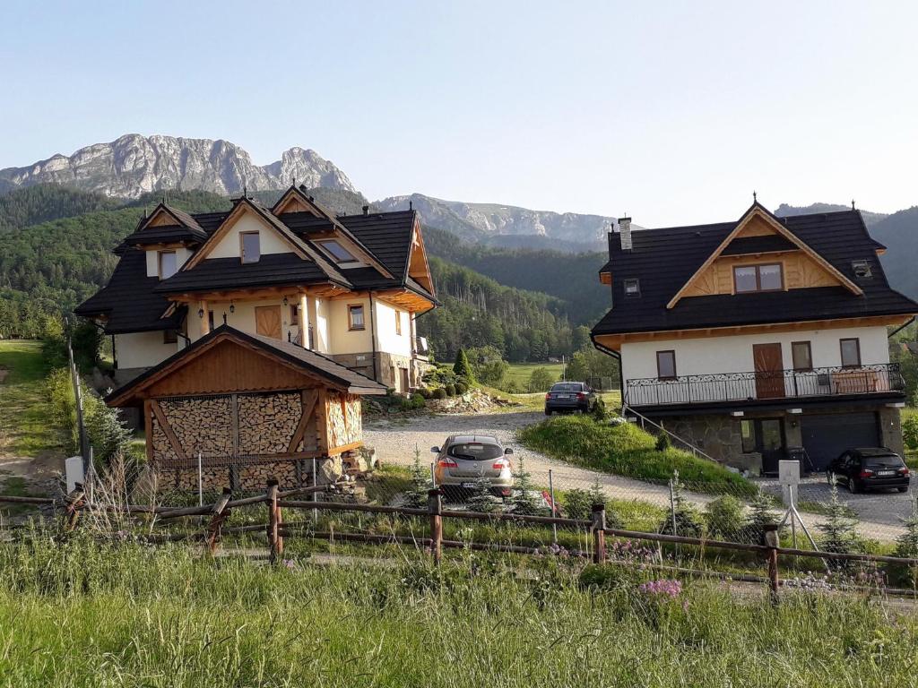um grupo de casas numa colina com montanhas ao fundo em Grażynka em Zakopane