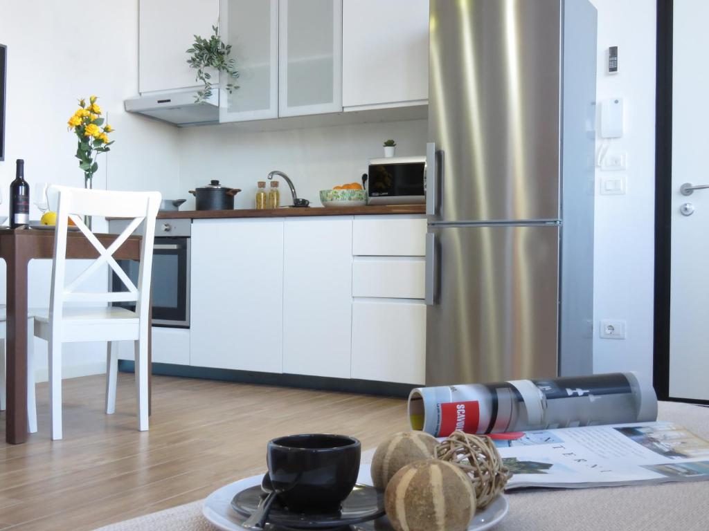 a kitchen with a refrigerator and a table with a camera at Lazzaretto Apartments in Bologna