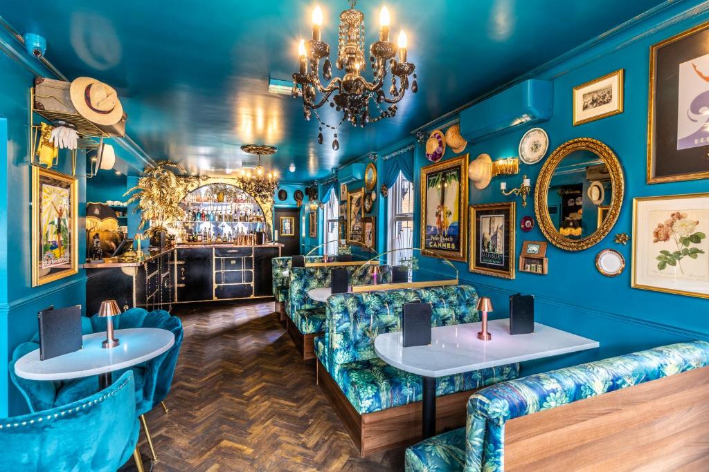 un bar con pareti e divani blu e un lampadario a braccio di Caboose a Salisbury