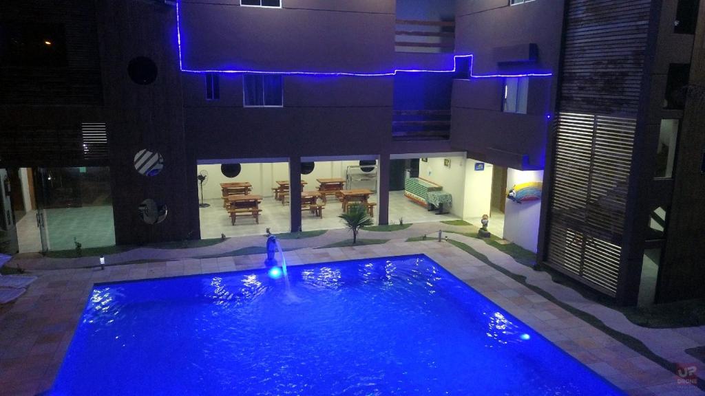 a large blue swimming pool in the middle of a building at Hotel Pousada WS in Porto De Galinhas