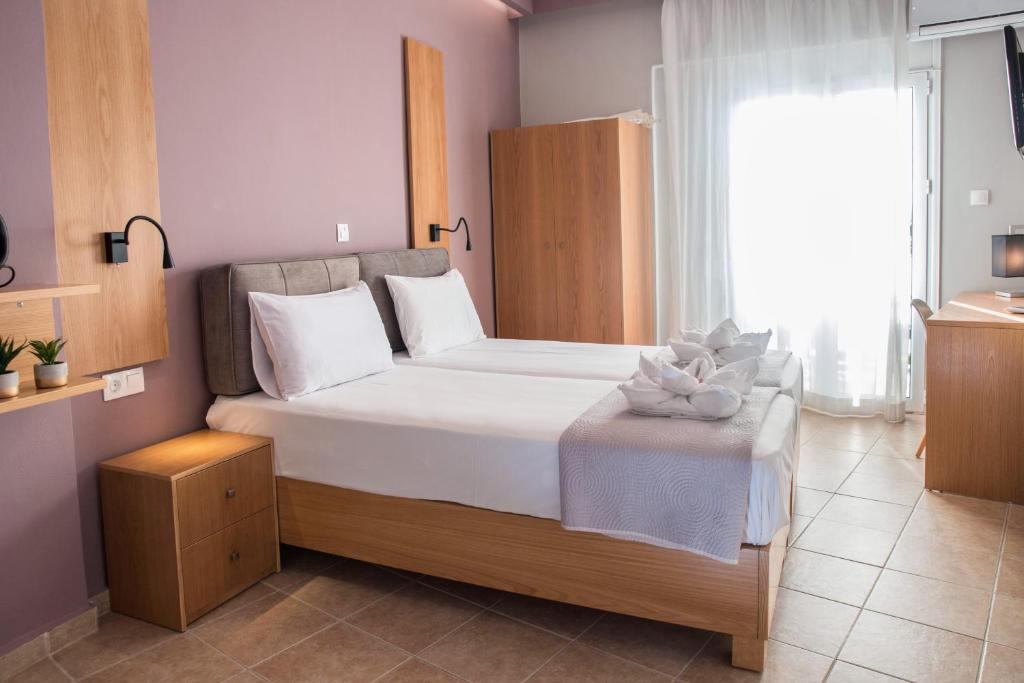 a bedroom with a large bed and a window at Semeli Studios in Chania Town