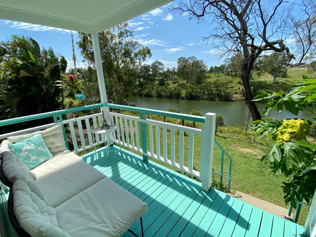 porche con sofá y vistas al río en Gaia Vida River Cottage, en Lowood