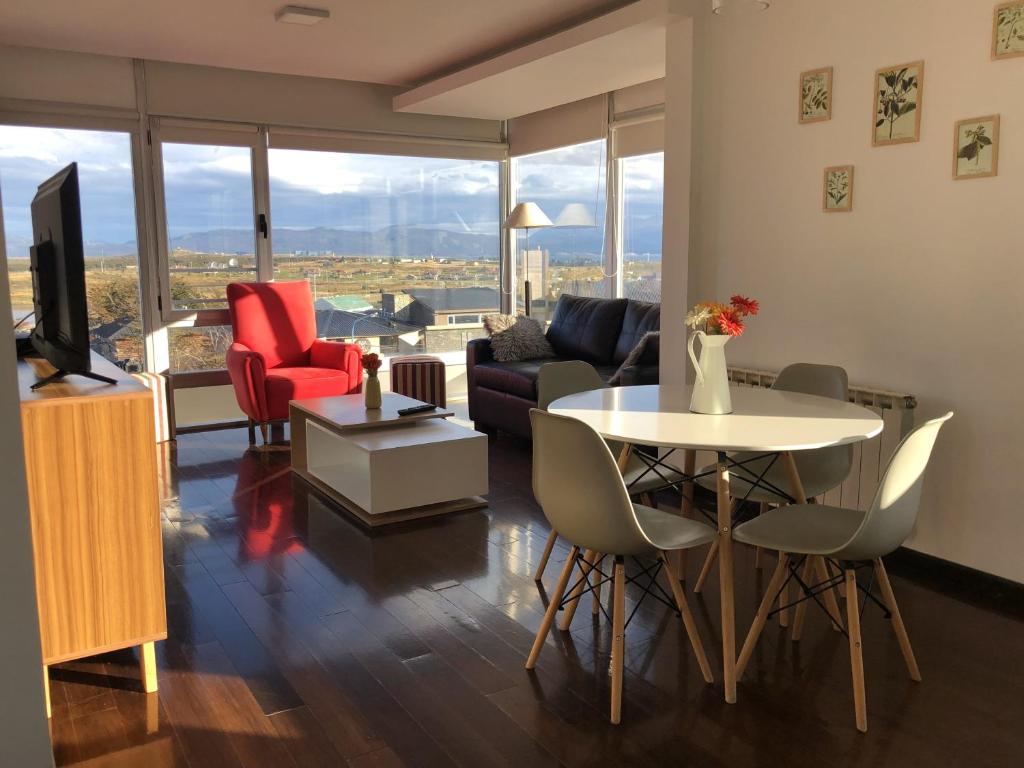 un soggiorno con divano, tavolo e sedie di Amaneceres del Beagle a Ushuaia