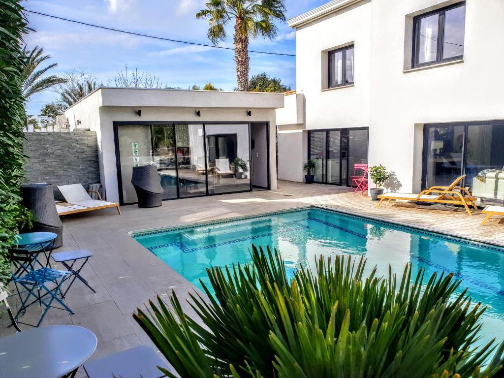 a swimming pool in front of a house at La Villa Blanche in Sanary-sur-Mer