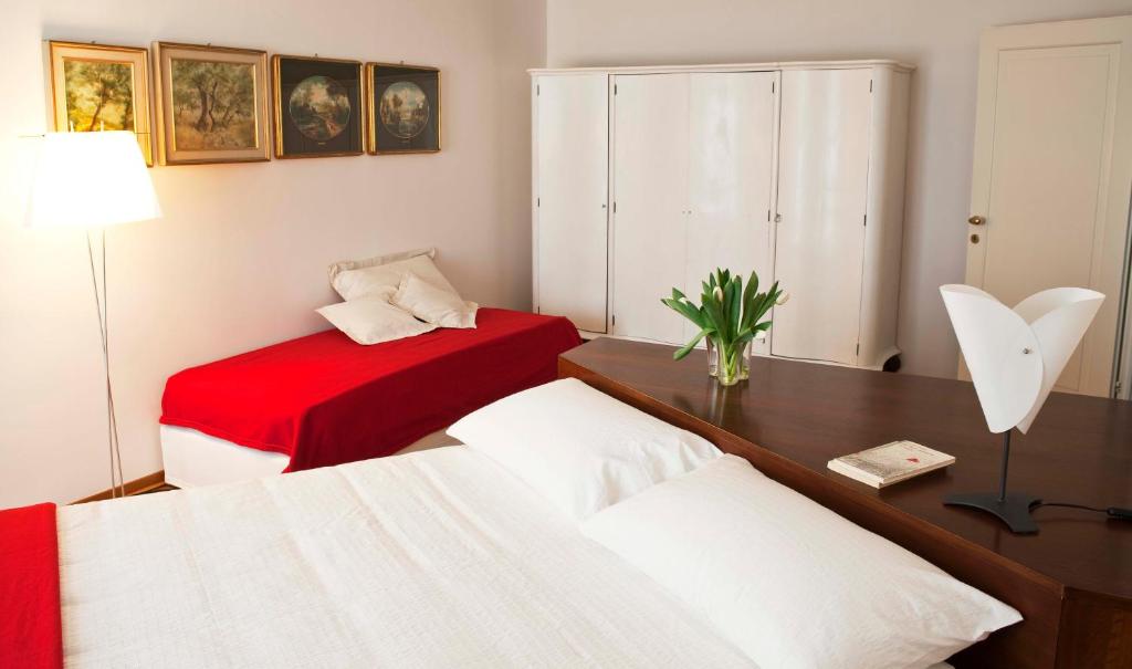 a bedroom with two beds and a desk with a lamp at B&B ViaCavourSei in Portogruaro
