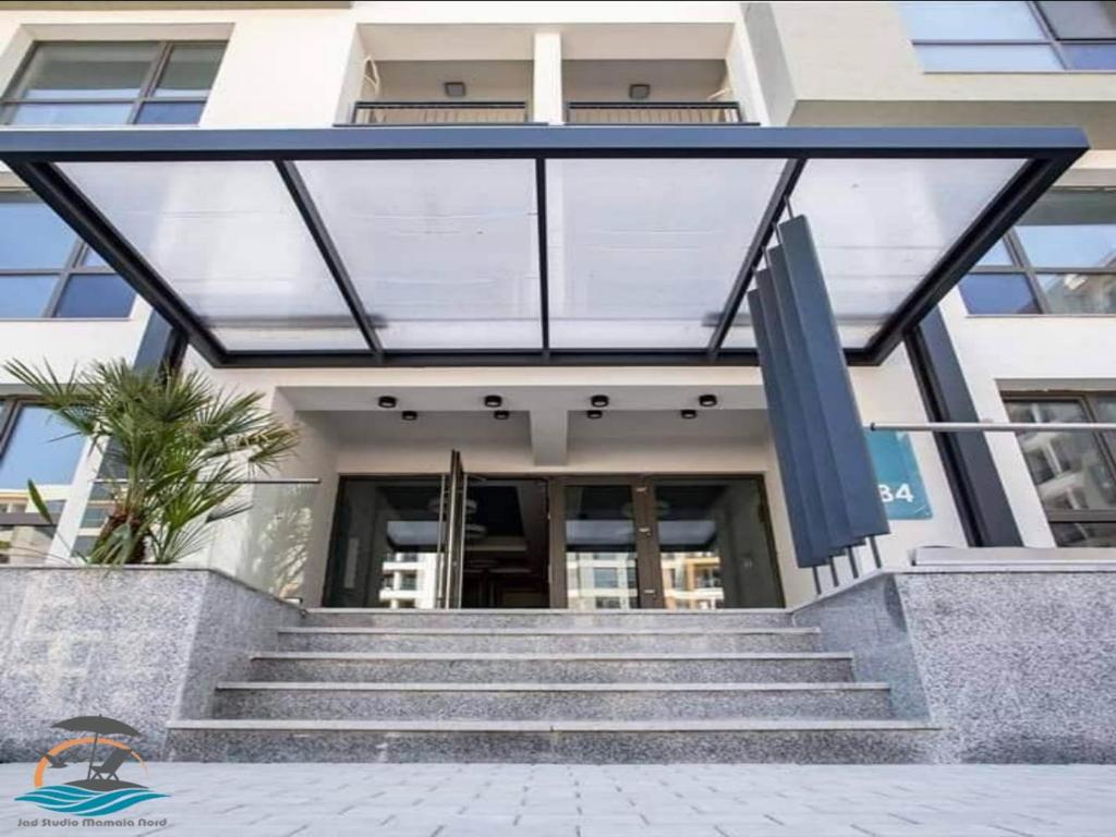 a building with glass doors and stairs in front of it at Jad Studio Mamaia Nord in Mamaia Nord