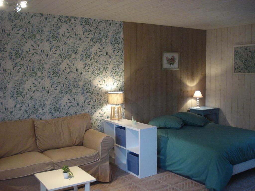 1 dormitorio con 1 cama y 1 sofá en Au p'tit jardin, en Saint-Sylvestre-de-Cormeilles