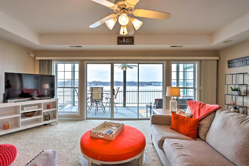 a living room with a couch and a flat screen tv at Waterfront Lake Ozark Condo - Patio and Pool Access in Lake Ozark