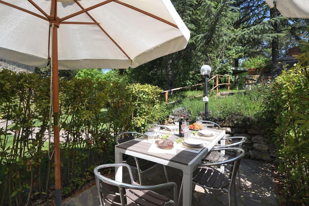 un tavolo con ombrellone in giardino di Vaniglia a Gaiole in Chianti