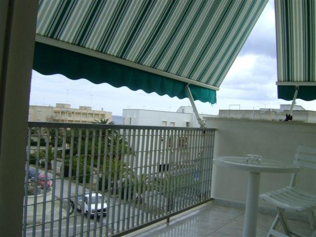 オートラントにあるAppartamento a Otranto con Vista Mareのバルコニー(テーブル、緑の傘付)