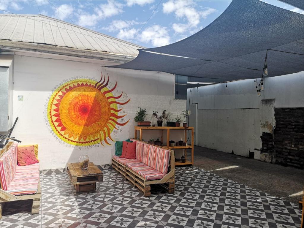 a patio with a sun mural on the side of a building at Hostal Vitalia in Santiago