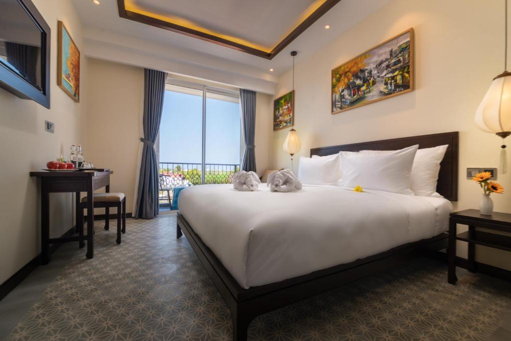 Postel nebo postele na pokoji v ubytování Hoi An Merrily De Art Hotel