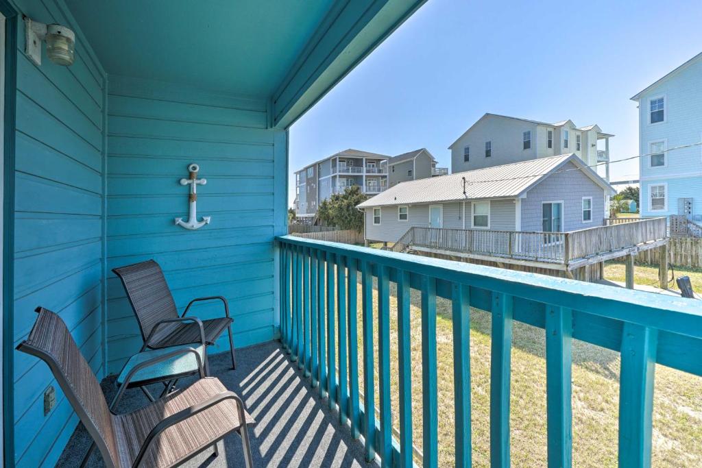 a balcony with two chairs and a cross at Condo with Balcony and Pool Walk to 2 Beach Accesses! in Carolina Beach