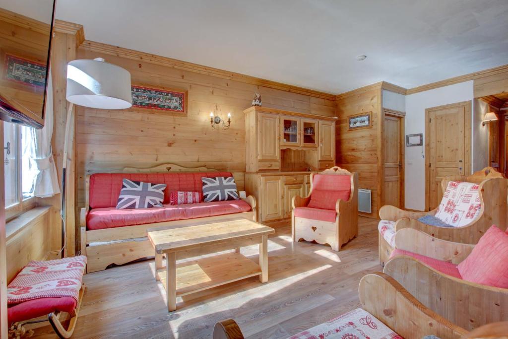 ein Wohnzimmer mit einem roten Sofa und Stühlen in der Unterkunft Lodge 3 in Morzine