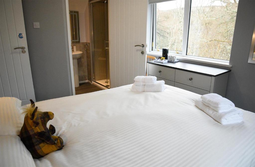 una camera da letto con un grande letto bianco con asciugamani di 5 Glenconon Bed and Breakfast a Uig