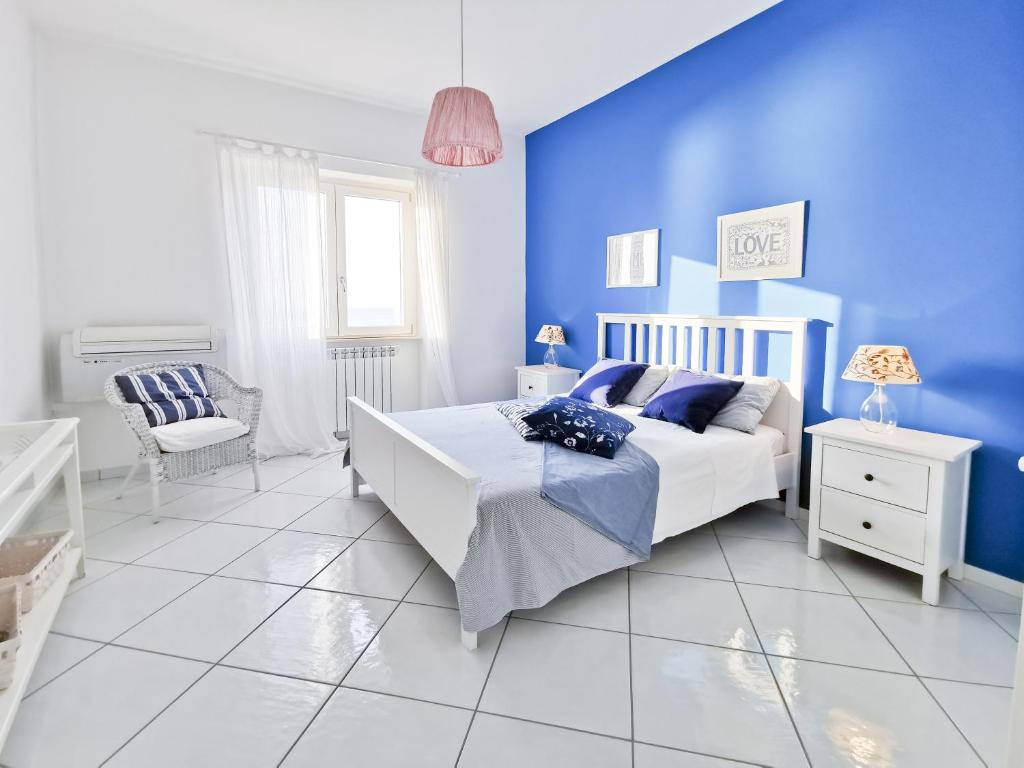 ピアノ・ディ・ソレントにあるSunset Modern Sea View Apartmentの青い壁のベッドルーム(ベッド1台付)