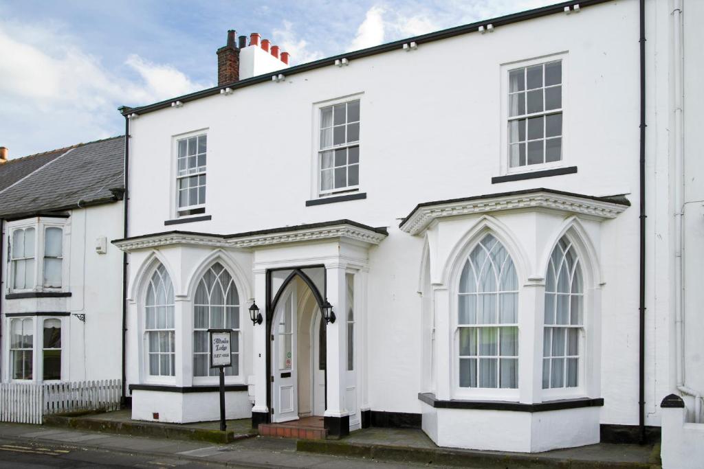 a white building with an archway and windows at Altonlea Lodge in Hartlepool