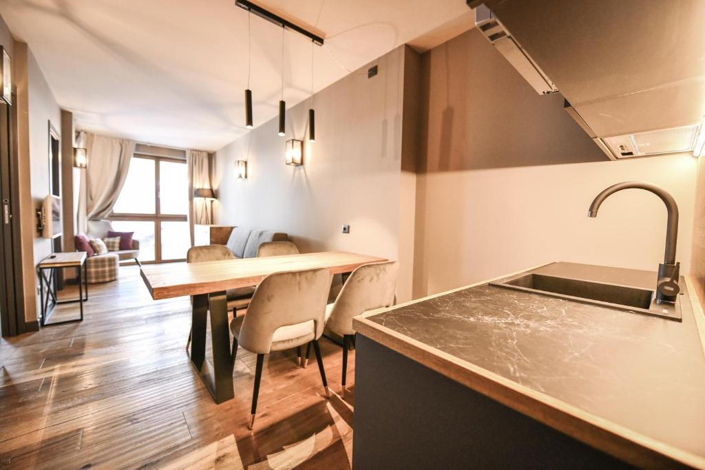 kuchnia i jadalnia ze stołem i krzesłami w obiekcie Chalet Everest - Luxury Apartments w mieście Prato Nevoso