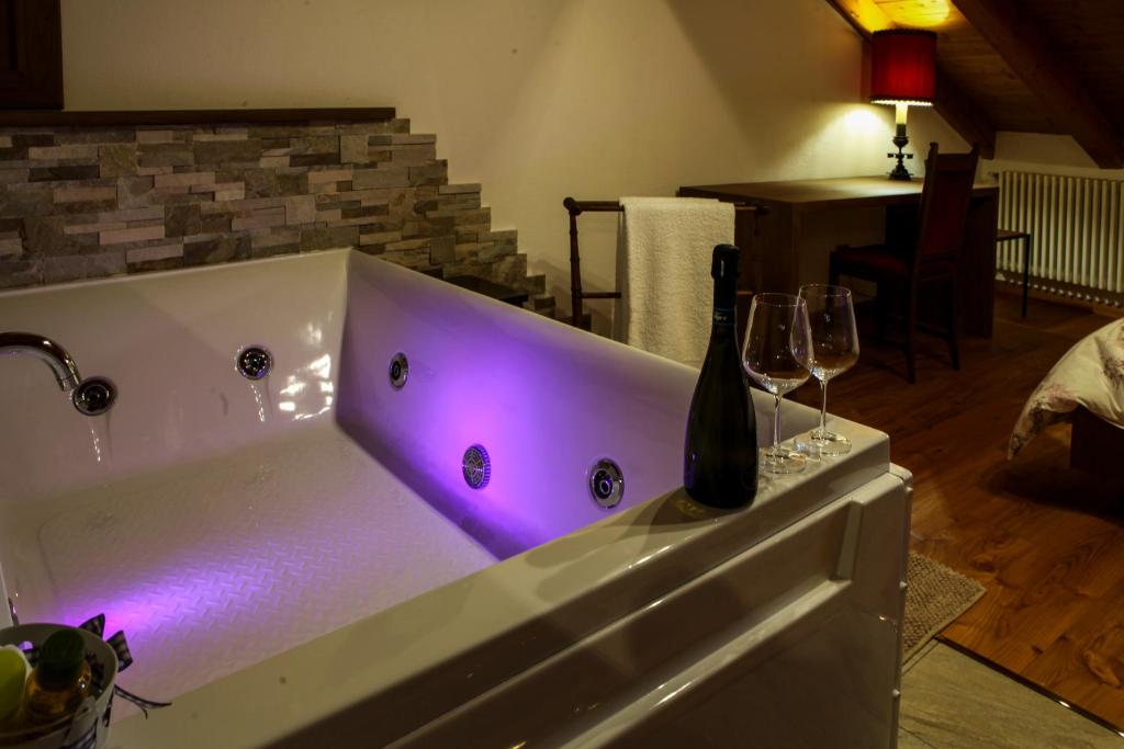 una vasca da bagno con una bottiglia di vino e due bicchieri di Maison Bordon - Le Petit Château a Nus
